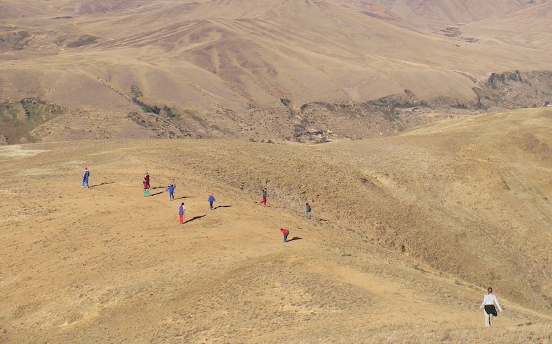Photo of a hilly grassland and kids in the Peruvian Altiplano.